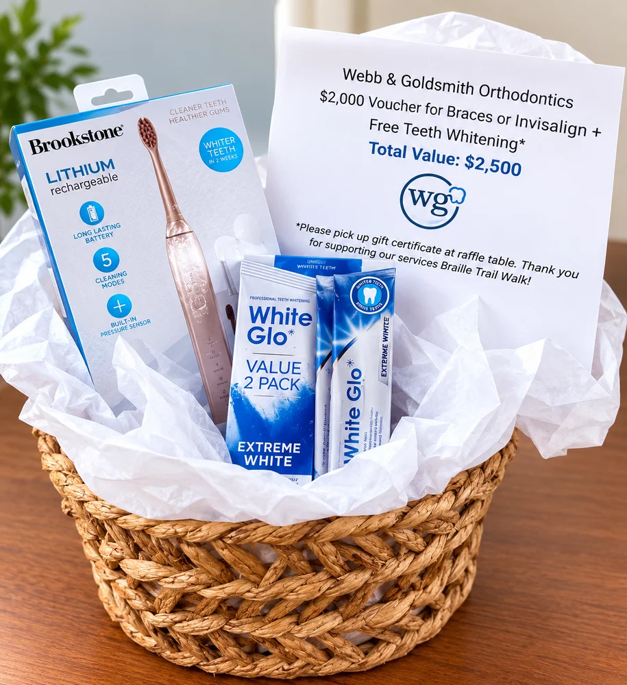 Woven basket holding a rechargeable electric toothbrush, two whitening kits and a printed gift certificate card.