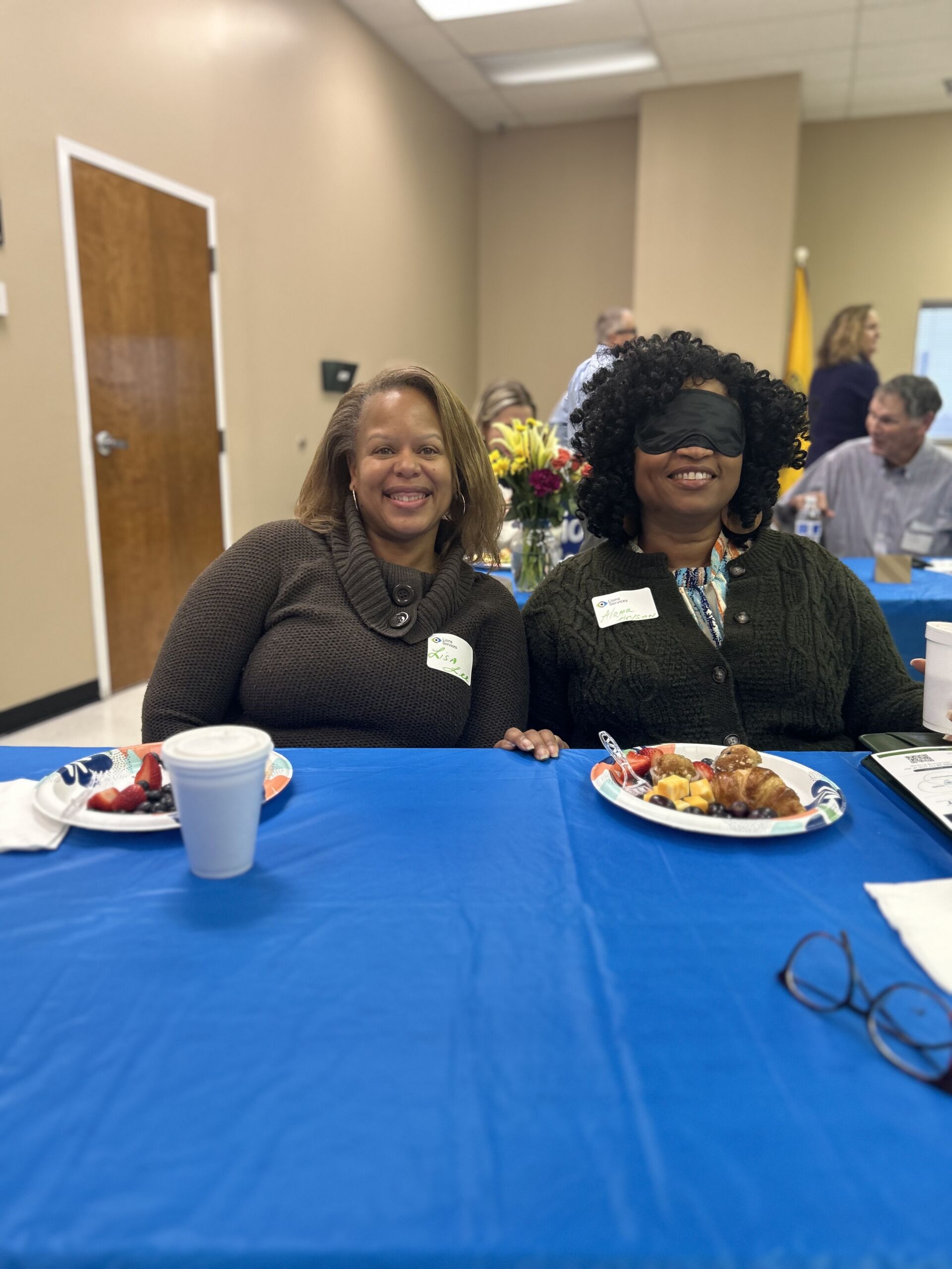 2 women with blindfolds smiling at the camera