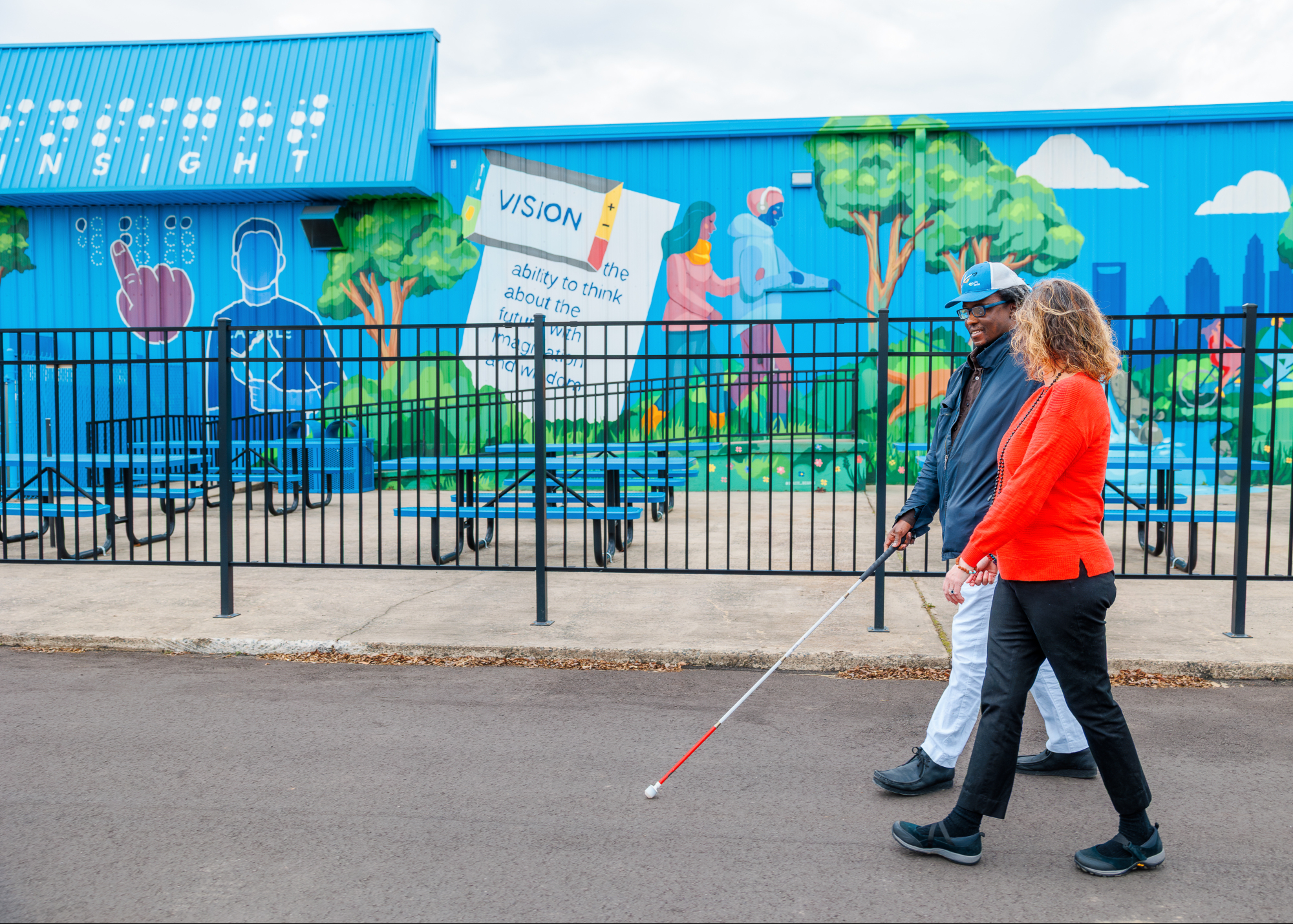 LionsServices26_104 male and female walking in front of a colorful mural
